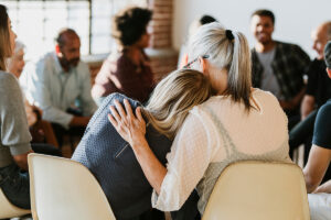 Two people hug as they discover benefits of group therapy