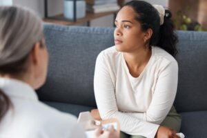 Woman looks out window after asking therapist what is dialectical behavior therapy